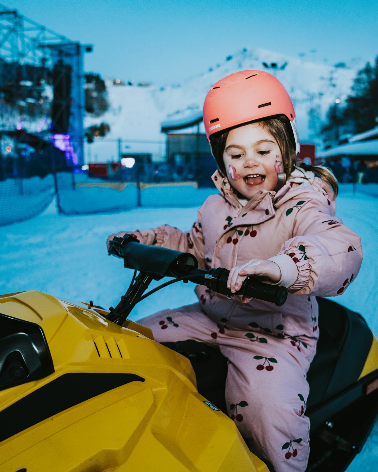 Una bambina con il casco sulla mini motoslitta gialla Discovery