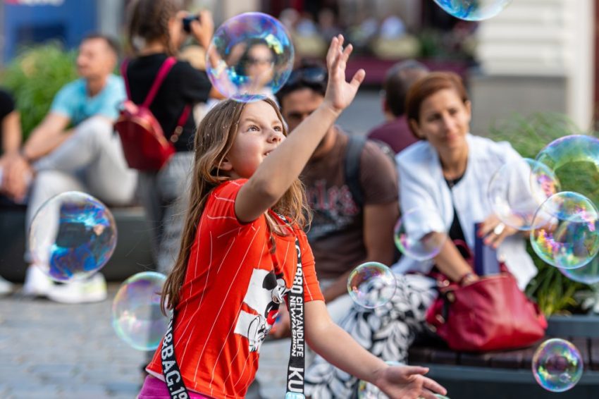 children-playing-with-colorful-soap-bubbles-floating-in-the-foreground-fun-bubble-soap-street-city_t20_lLKR4Q