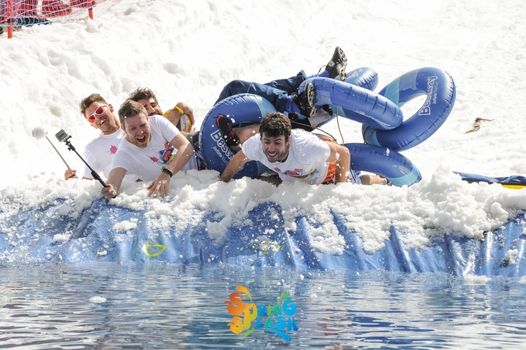 Un equipaggio con gonfiabili blu affronta la discesa innevata verso la piscina nello Spring Splash 2016