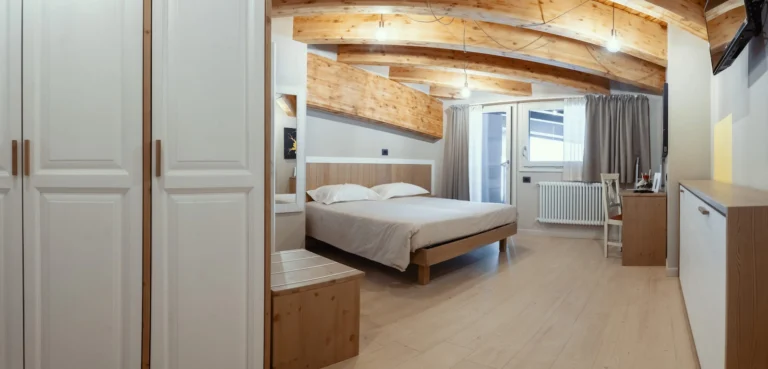 Una camera dell’Hotel Laghetto, con travi a vista e ambienti chiari