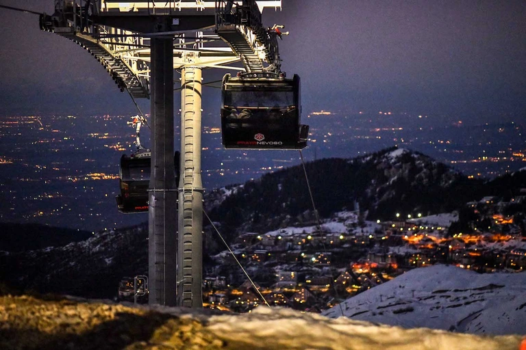 Una cabina de La Rossa di sera, con le luci della valle sullo sfondo