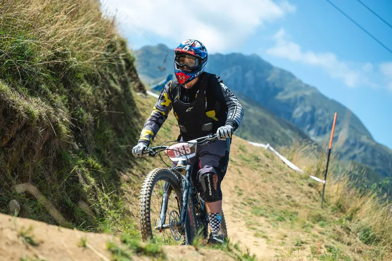 Giovane rider con casco integrale sul sentiero sterrato del Bikepark