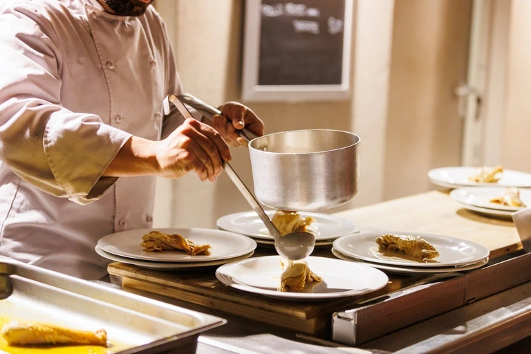 Uno chef impiatta un primo sul banco della cucina dello Chalet Il Rosso