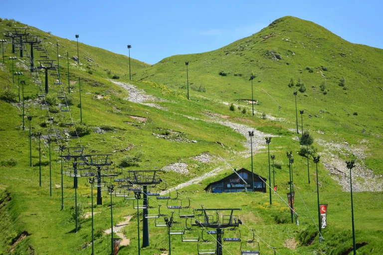 Pendio erboso verde con vecchi impianti e chalet.