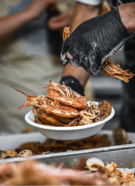 Preparazione di un piatto di pesce fritto negli stand della sagra