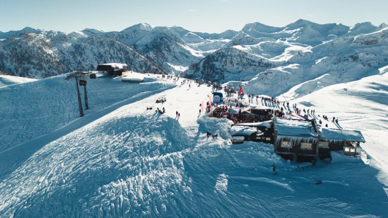 Veduta aerea dello Chalet Il Rosso e dell’arrivo della telecabina La Rossa tra le montagne innevate.