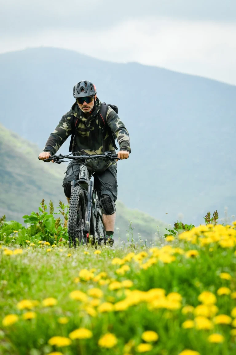 Una persona pedala in e-bike tra i prati di montagna