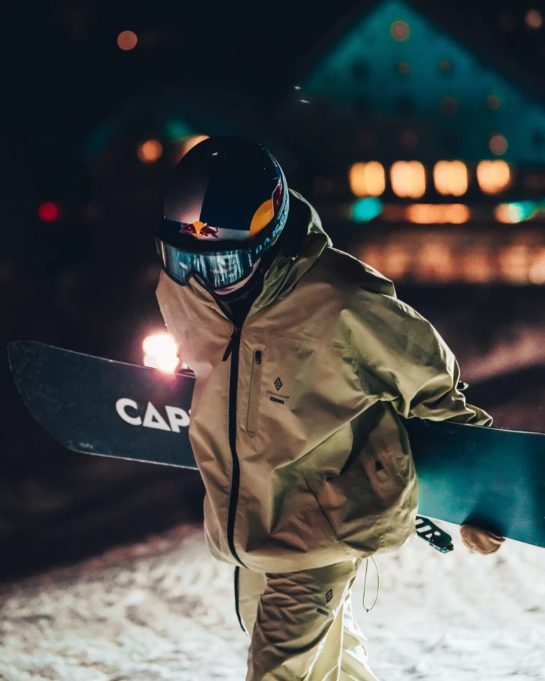 Snowboarder con casco in primo piano di notte