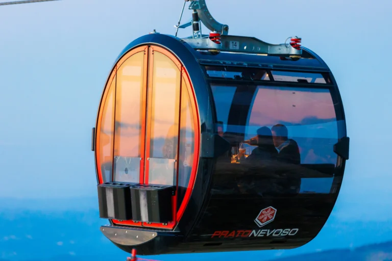 Una cabina de La Rossa illuminata e apparecchiata per la Sky Dinner, nel paesaggio del crepuscolo