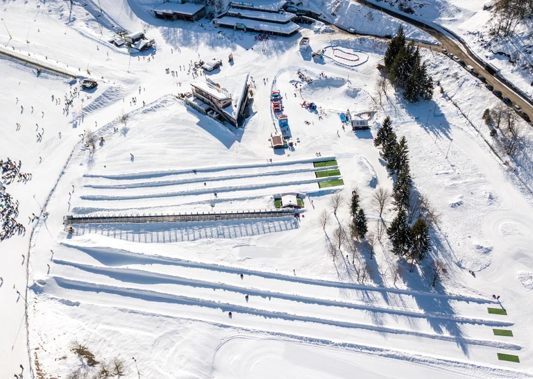 Il Village visto dall’alto nella Conca innevata, con le piste parallele dello Snowtubing e la risalita coperta