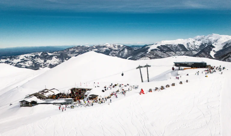 Lo Chalet Il Rosso con la terrazza sulla neve e l’arrivo della telecabina La Rossa, visti dal drone.