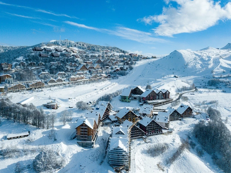 Prato Nevoso innevata vista dall’alto: le case del paese, le strade e le piste sullo sfondo