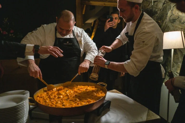 Due chef servono un risotto durante una cena di Gusto Montagna