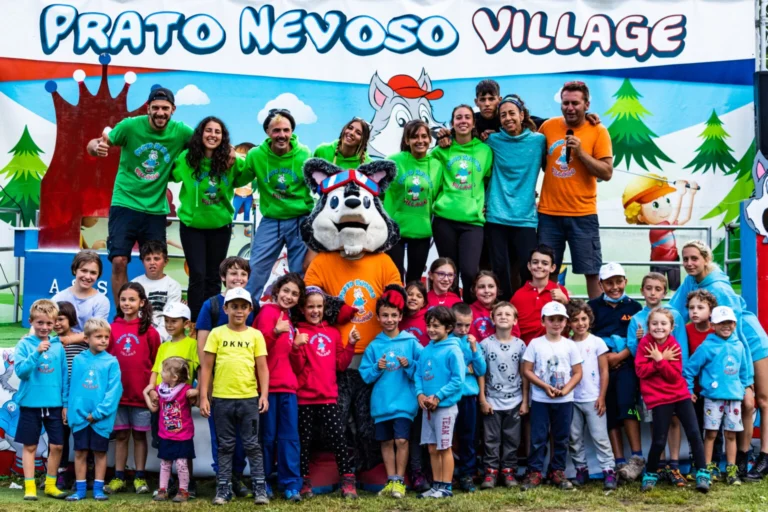 Bambini e animatori riuniti con Asso davanti al palco del Prato Nevoso Village