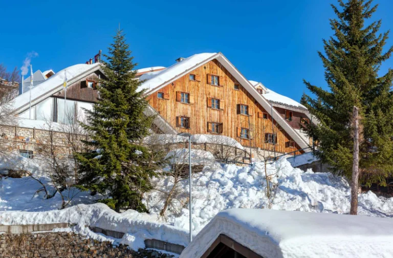 Il Family Hotel Mondolè di Prato Nevoso, con la facciata in legno e la neve.