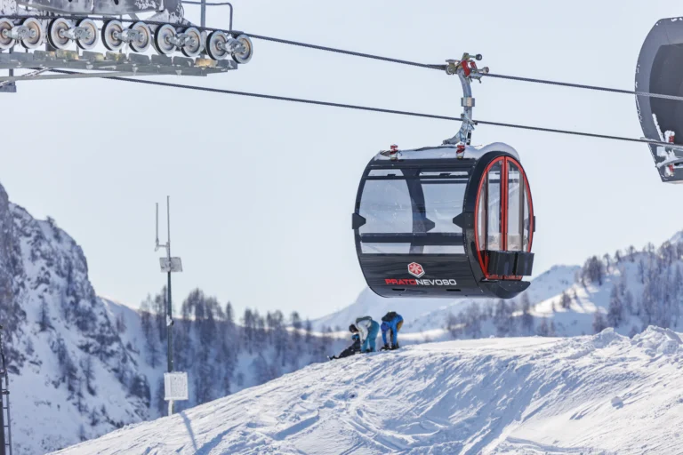 Una cabina panoramica della telecabina La Rossa sospesa sopra la neve di Prato Nevoso.