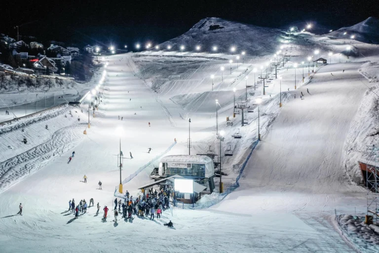 Sciatori sulle piste illuminate della Conca di notte