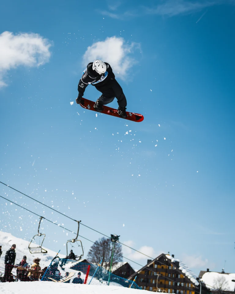 Snowboarder in alto nel salto contro cielo blu