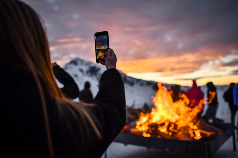 Persone al tramonto in quota accanto a un braciere acceso