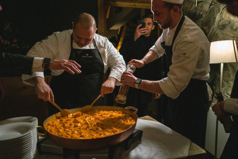 Due chef servono un risotto durante una serata di Gusto Montagna
