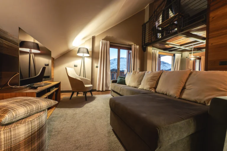 Il soggiorno della Super Suite di Chalet Everest, con soppalco e vista sulle montagne.